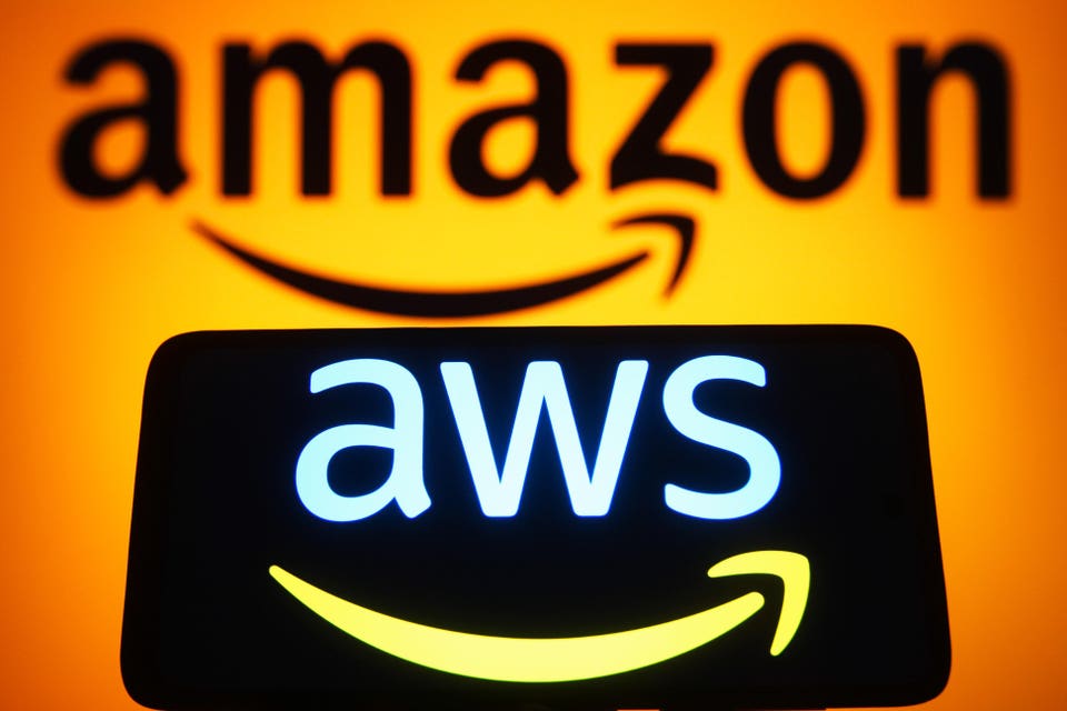 Logotipo de AWS en el teléfono inteligente y logotipo de Amazon sobre fondo naranja. 