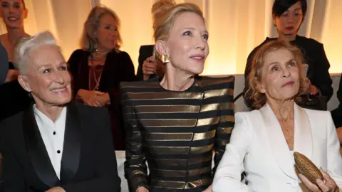 Fotos de Genty cerca de Cate Blanchett y Lauren Hutton sentadas en la fila