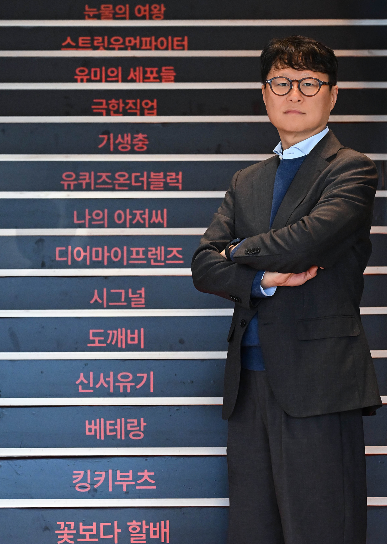 Yea Ju-yeol, jefe de la División de Artes Escénicas de CJ ENM, se encuentra frente a una escalera que muestra los programas de armas de la compañía en el Centro CJ ENM en Sangam-dong, Mapo-gu, Seúl, el 3 de diciembre. (Lee Sang-sub/The Korea Herald)