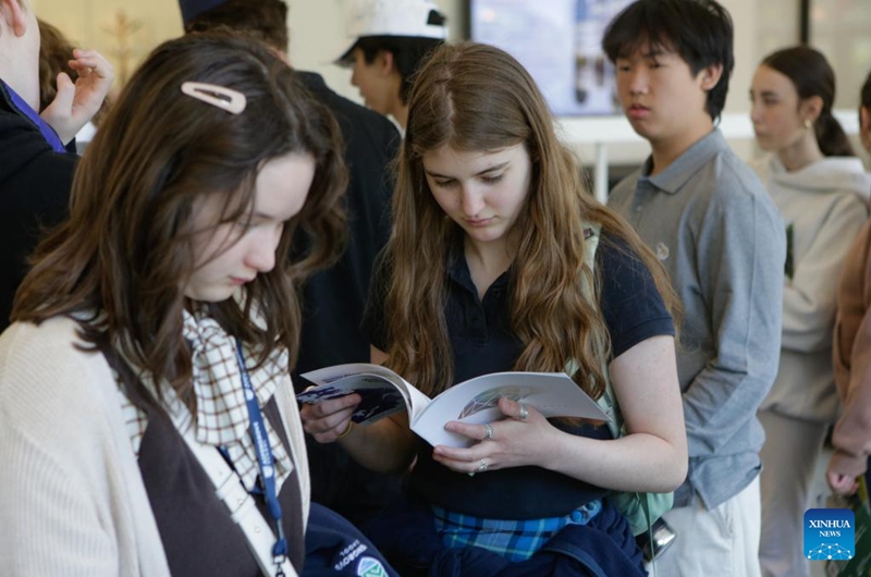 Un estudiante mira un cartel universitario durante la Feria Mundial de Universidades en Vancouver, Columbia Británica, Canadá, 25 de abril de 2026. Asistieron representantes de diferentes universidades y facultades de muchos países, brindando a estudiantes y padres la oportunidad de explorar opciones de educación superior internacional y oportunidades de admisión. (Foto de Liang Sen/Xinhua)